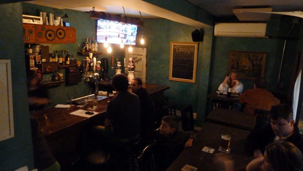 Bar, several taps, TV, and a couple occupied tables